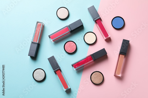 Composition of lipsticks and eyeshadows on color background, flat lay