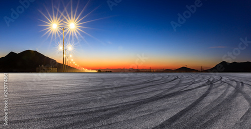 Asphalt road ground and bright street lights landscape at sunset panoramic view