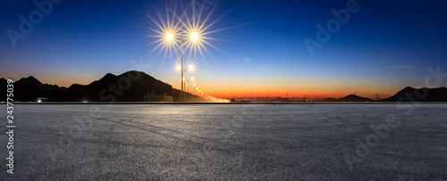 Asphalt road ground and bright street lights landscape at sunset,panoramic view
