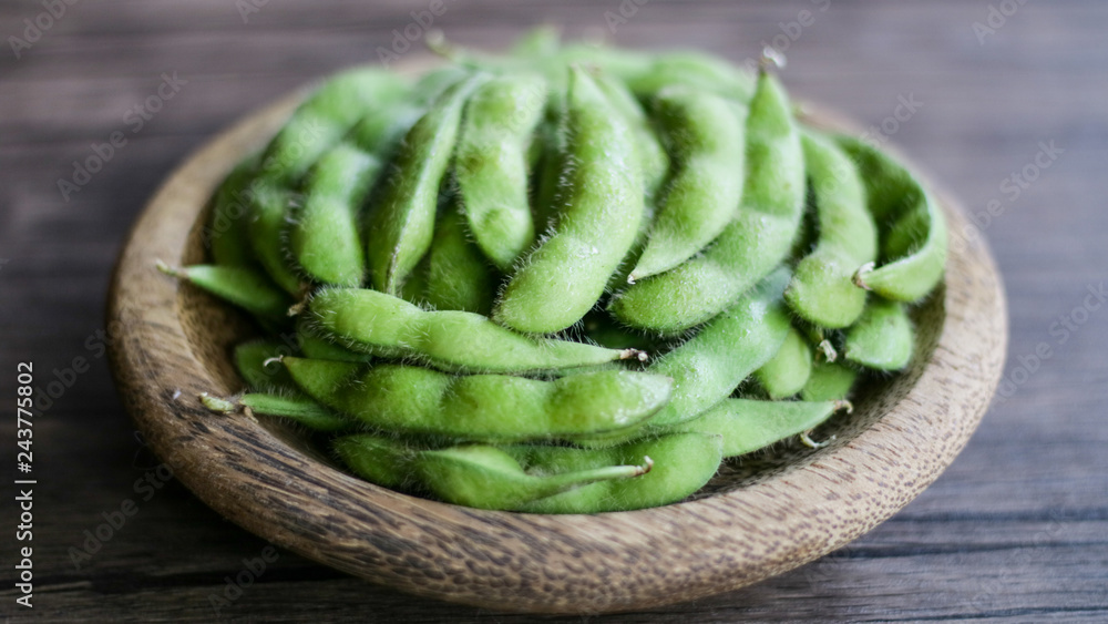 Young soy beans or edamame on wood background. Young soy beans or edamame on wood background.