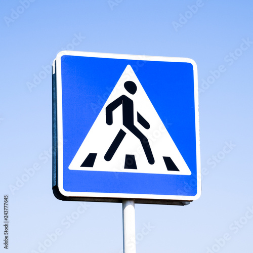 A pedestrian crossing sign. Sign on a blue sky background.