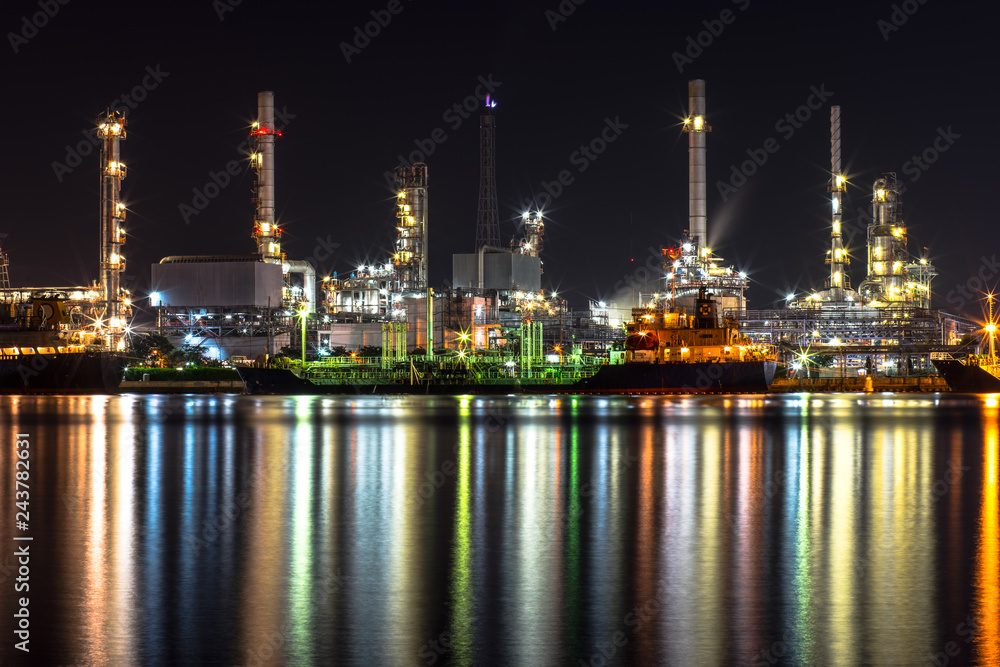 Oil refinery, tanker ship and petrochemical plant at night beside Chao Phaya river, Thailand. Colorful light reflection. Oil refinery, tanker ship and petrochemical plant at night beside Chao Phaya river, Thailand. Colorful light reflection.