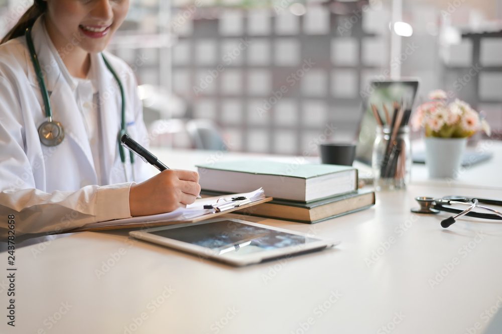 Woman doctor working with report paper in office hospital. Woman doctor working with report paper in office hospital.