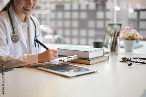 Woman doctor working with report paper in office hospital. photo