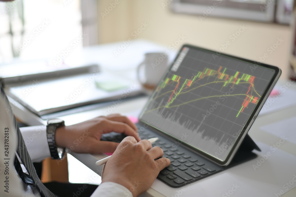Cropped shot of photo business man reading a report finance on digital tablet in workplace. Cropped shot of photo business man reading a report finance on digital tablet in workplace.