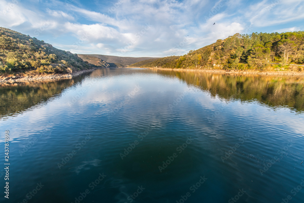 Extremadura and the Tietar river crossing the rugged terrain making a Lagoon. Amazing Monfragüe National Park landscape full of colors and water reflections of the cloudy sky, nice travel destination
