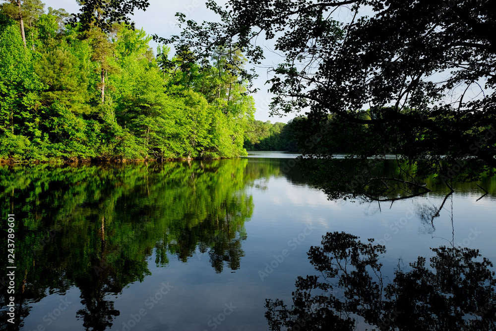 Calm scenic view with beautiful sky and tree reflections at Lake Johnson Park in Raleigh North Carolina. Calm scenic view with beautiful sky and tree reflections at Lake Johnson Park in Raleigh North Carolina.