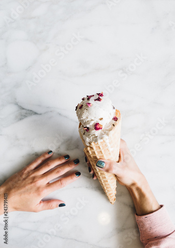 Overhead view of woman's hand holding ice cream cone