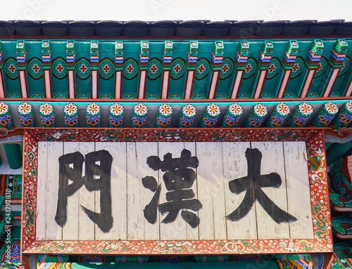 Traditional Korean colorful wooden frame written in Chinese the name of the building in Deoksu palace. photo