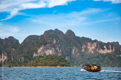 Long-tail Taxi boat with passengers. View of mountains and islands,