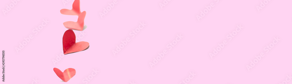 vertical line of Red paper hearts shape isolated on pink background selected focus soft focus long banner