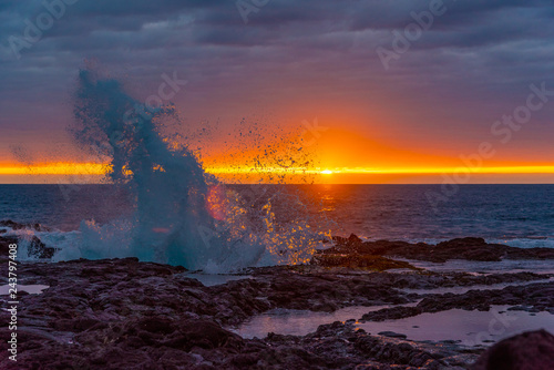 Big waves breaking onshore during sunset over ocean
