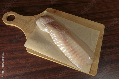 Raw cod fillet on a cutting board. Healthy eating. photo