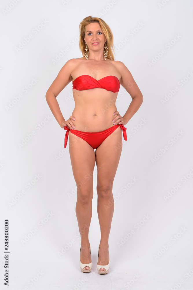 Full body shot of happy mature woman in bikini ready for vacation Photos |  Adobe Stock