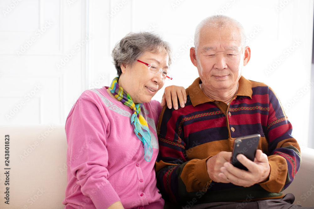 happy senior couple looking at mobile phone happy senior couple looking at mobile phone