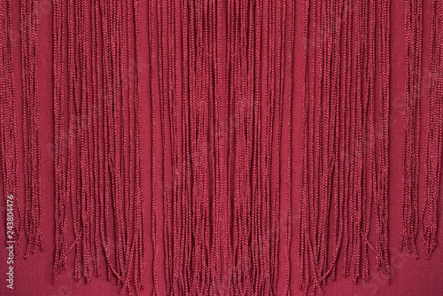 Maroon fabric with fringe. Close-up. Background