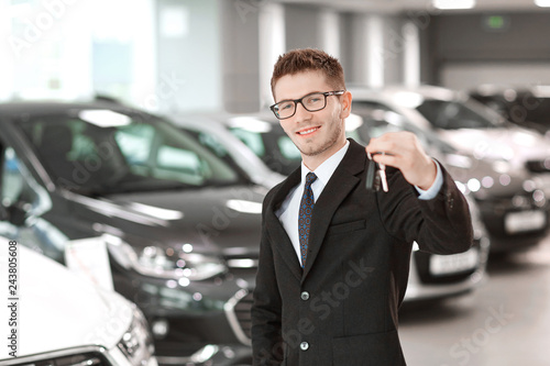 Wallpaper Mural The seller of cars with the keys in hand in the auto showroom. Torontodigital.ca