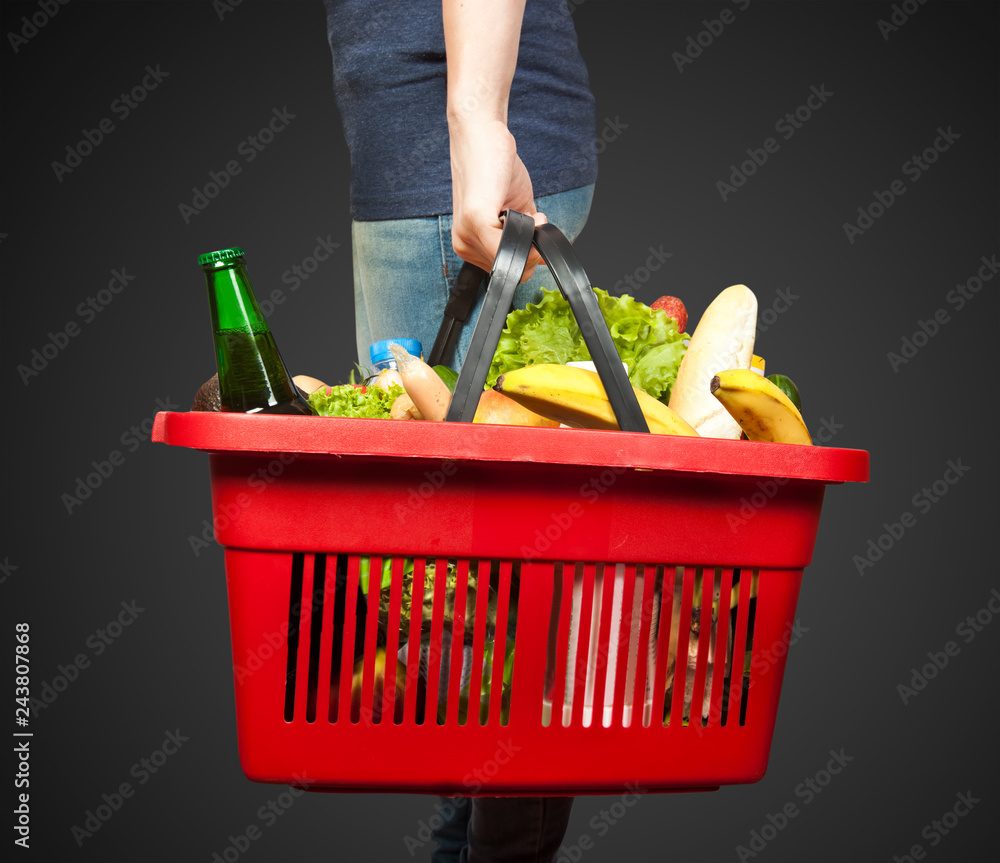 Basket with groceries in woman hand