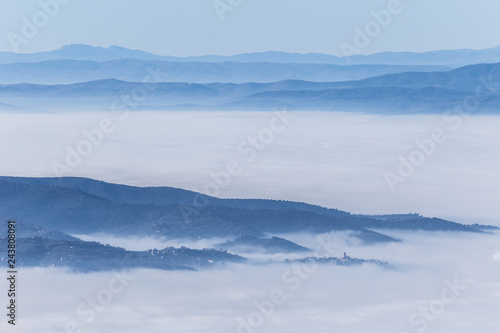 Fog filling a valley in Umbria (Italy), with layers of mountains and hills and various shades of blue © Massimo