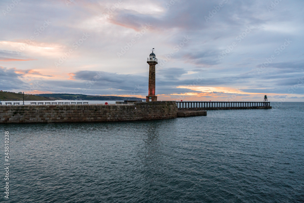 Evening light over the West Pier in Whitby harbour, North Yorkshire, England, UK - seen from the East Pier Evening light over the West Pier in Whitby harbour, North Yorkshire, England, UK - seen from the East Pier