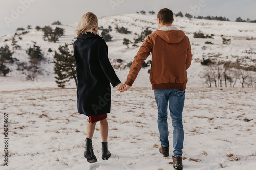 couple holding by hands, winter time.