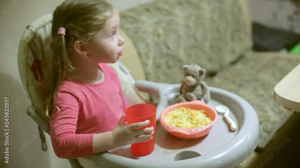 little girl eating rice with vegetables in the kitchen little girl eating rice with vegetables in the kitchen