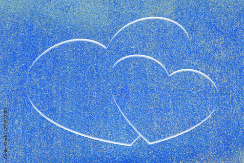 Two drawn hearts on blue surface of wall close-up. Urban background with two painted hearts. Imperfect decorative stucco with love symbol graffiti. Valentine day image. Unideal plane with copy space.