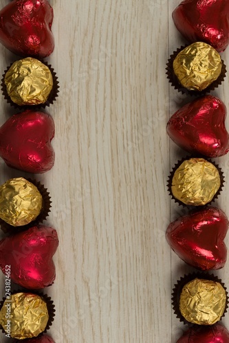 Chocolates and heart shape decorations arranged on wooden table