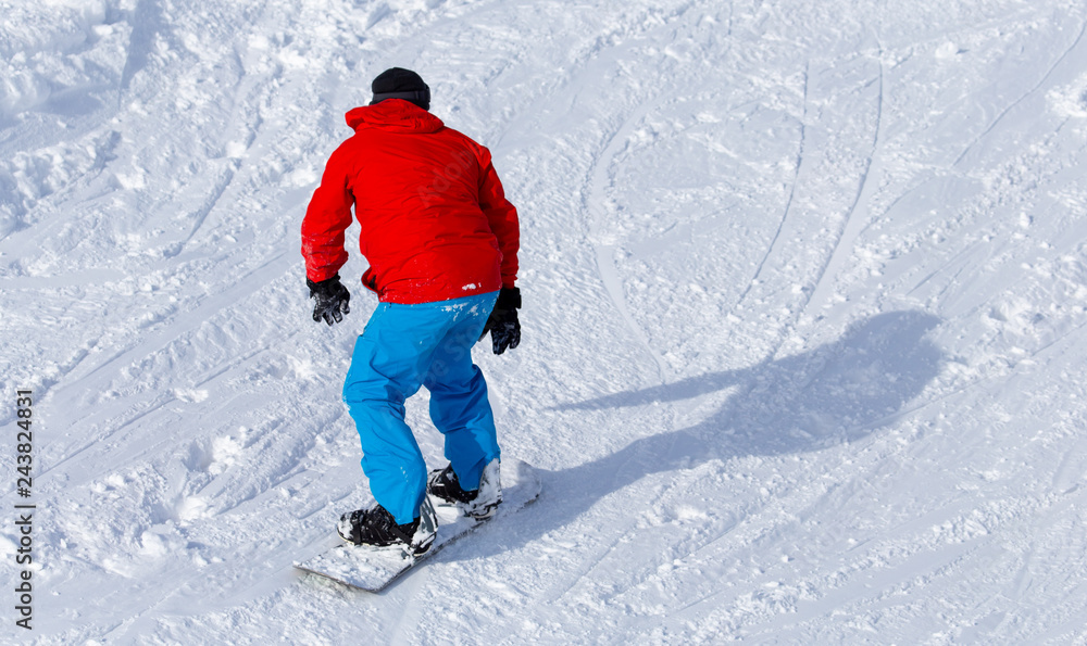 A man snowboarding a mountain in the snow in winter