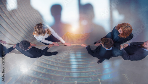 Fotografia Rival business man and woman compete for the command by pulling the rope