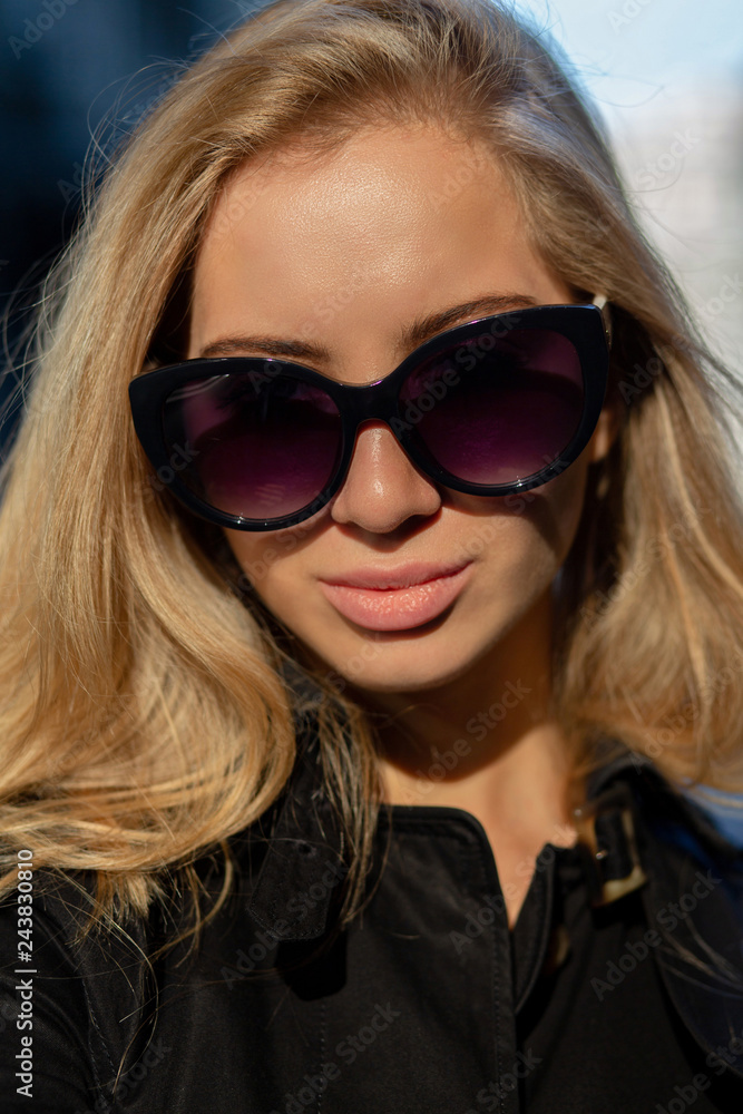 Closeup shot of attractive woman with natural makeup wearing black trench coat and glasses Closeup shot of attractive woman with natural makeup wearing black trench coat and glasses