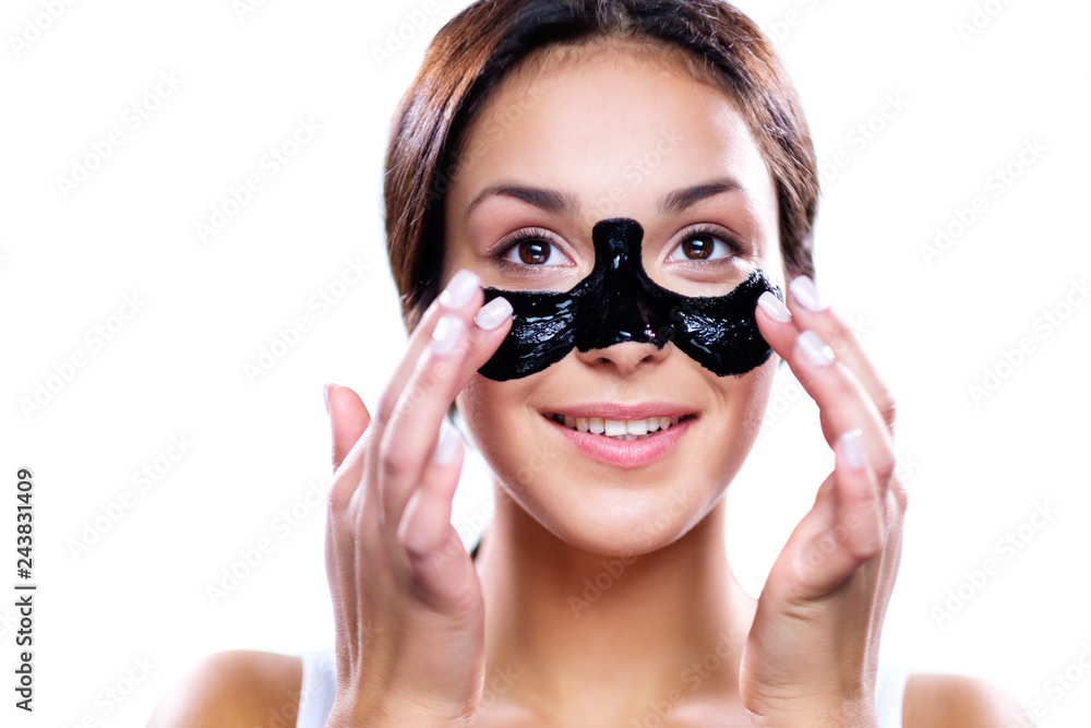 Beautiful woman applying coal mask Beautiful woman applying coal mask
