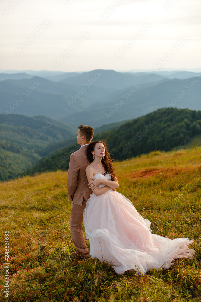 Stylish young bride and groom stand in boat on background cloude sky sea and mountains of Montenegro Stylish young bride and groom stand in boat on background cloude sky sea and mountains of Montenegro