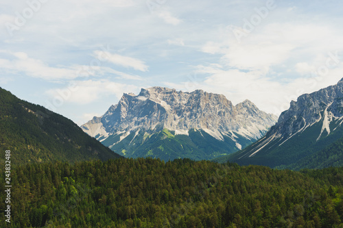 the mountain Zugspitze photographs from the Austrian side. The mountain lies in the middle of the picture and is lined by the wooded environment