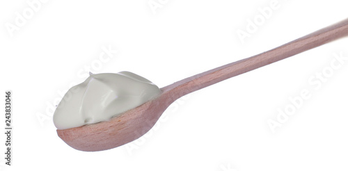 Mayonnaise in a wooden spoon on a white isolated background. white sauce. close-up.