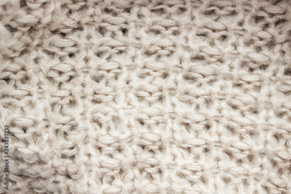 Knitted texture of beige wool threads close-up. Knitted texture of beige wool threads close-up.