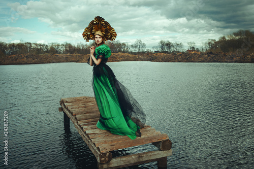Beautiful model is posing wearing green dress and kokoshnik photo
