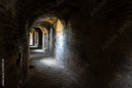 Curved stone tunnel with sun light beams