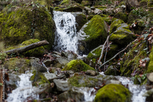 Krasnaya Polyana, Sochi, Russia. Waterfall in spring and green moss on the rocks