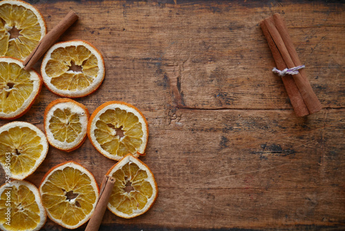 dry orange and cinnamon slices on wooden background