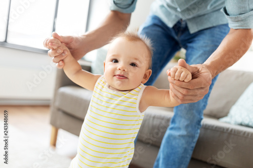Φωτογραφία family, toddling and babyhood concept - father helping little baby daughter with