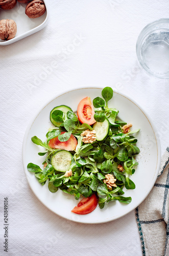salad dish with tomatoes lattuce chestnuts on a white table