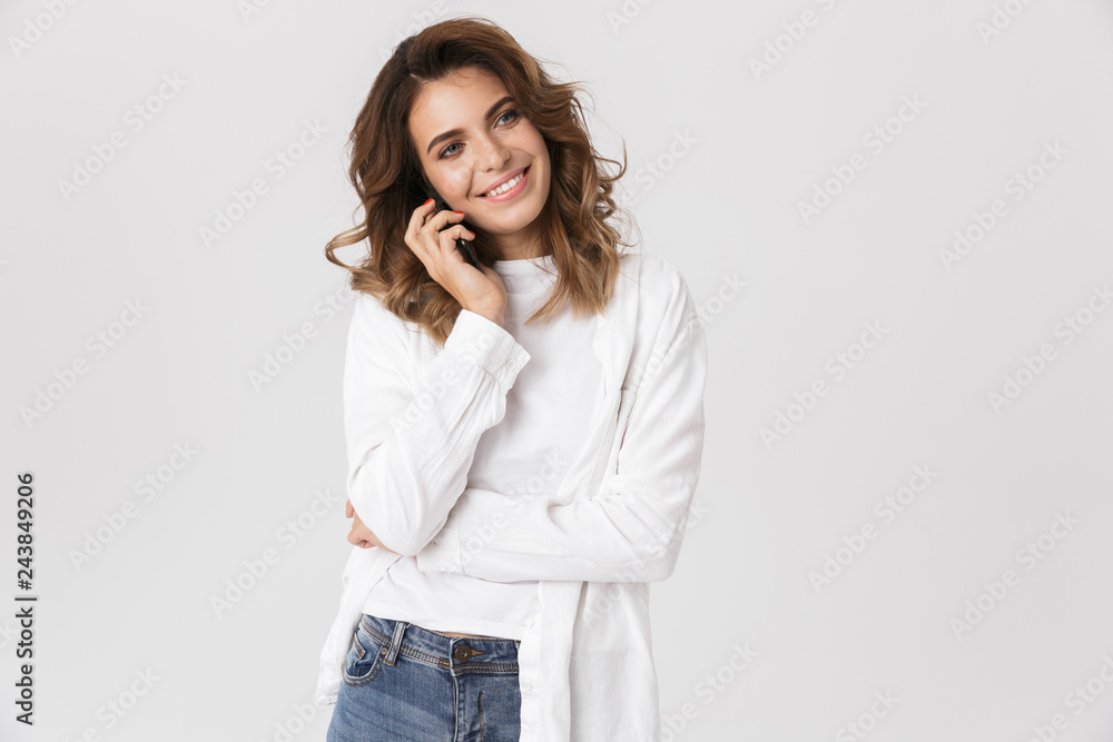 Portrait of attractive woman in casual clothes talking on mobile phone, while standing isolated over white background Portrait of attractive woman in casual clothes talking on mobile phone, while standing isolated over white background