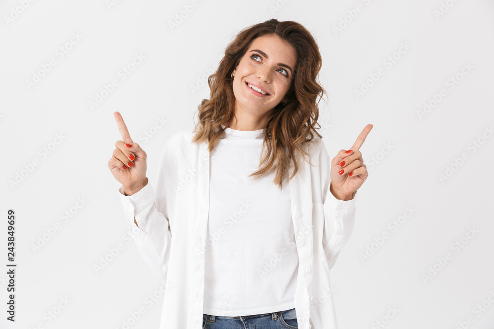 Portrait of happy woman in casual clothes pointing fingers upward, isolated over white background Portrait of happy woman in casual clothes pointing fingers upward, isolated over white background