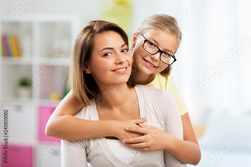 people and family concept - portrait of happy mother and daughter at home