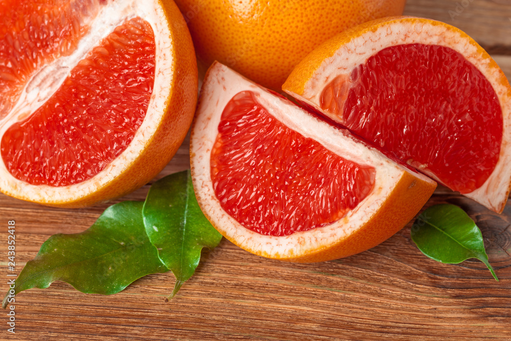 Grapefruit with slices on a wooden table. Grapefruit with slices on a wooden table.