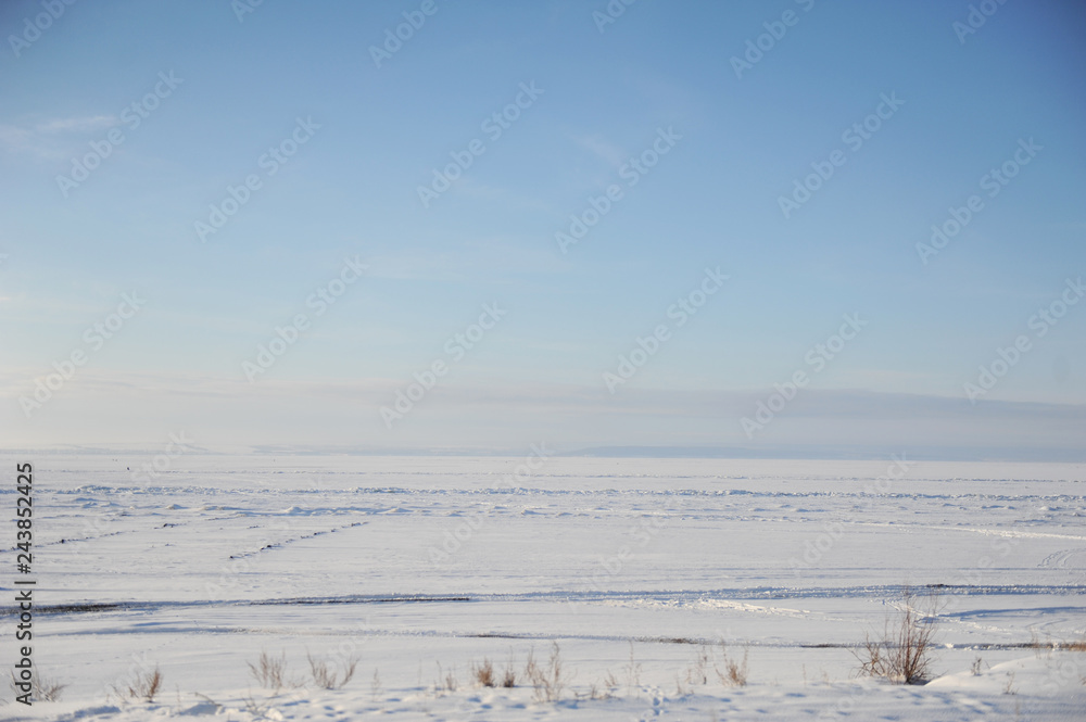 Winter snow landscape. Endless space of a frozen river