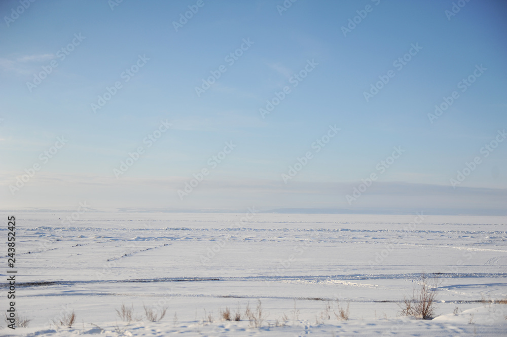 Winter snow landscape. Endless space of a frozen river Winter snow landscape. Endless space of a frozen river