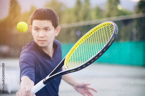 Man holding racket about to hit a ball in tennis court - people in tennis game match concept © pairhandmade