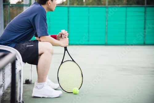 Sad tennis player sitting in the court after lose a match - people in sport tennis game concept © pairhandmade